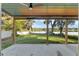 Covered patio with ceiling fan overlooking expansive lawn and lake at 754 Se 167Th Court Rd, Silver Springs, FL 34488