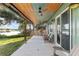 Covered patio with chairs and grill overlooking expansive lake and yard at 754 Se 167Th Court Rd, Silver Springs, FL 34488