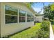 View of the house and backyard with well-kept lawn, bordered by lush green foliage, from a low angle at 8524 Sw 90Th Ln # B, Ocala, FL 34481