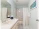 Bright bathroom featuring a single sink vanity, toilet, shower, and large mirror at 8524 Sw 90Th Ln # B, Ocala, FL 34481