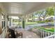Inviting front porch with white railings, two chairs and view of landscaping and street at 8524 Sw 90Th Ln # B, Ocala, FL 34481