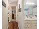 Inviting hallway with wood floors that transitions into a full bathroom with a single sink vanity at 8524 Sw 90Th Ln # B, Ocala, FL 34481