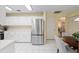 Open kitchen with stainless steel refrigerator, ample cabinet space, and adjacent dining area at 8524 Sw 90Th Ln # B, Ocala, FL 34481