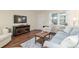 Bright living room with plush seating, wood floors, and a mounted television at 8524 Sw 90Th Ln # B, Ocala, FL 34481