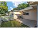 Exterior view of home featuring an AC unit, concrete patio, a white picket fence and a well-maintained lawn at 8681 Sw 93Rd Pl # B, Ocala, FL 34481