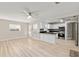 Spacious open-concept living room featuring light wood floors that connect seamlessly with the updated kitchen at 8681 Sw 93Rd Pl # B, Ocala, FL 34481