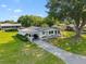 Aerial view of a charming home with covered porch, lush landscaping, and a long driveway nestled among mature trees at 8973 Sw 103Rd Ln, Ocala, FL 34481