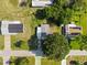 Aerial view of a home with a covered area, mature trees, and a surrounding grassy yard in a residential neighborhood at 8973 Sw 103Rd Ln, Ocala, FL 34481