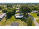 Aerial view of a cozy home shaded by mature trees, with a long driveway, and lush green surroundings in a quiet neighborhood at 8973 Sw 103Rd Ln, Ocala, FL 34481