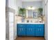 Bright blue cabinets complement the white walls and mirror at 8973 Sw 103Rd Ln, Ocala, FL 34481