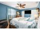 The well-lit bedroom has a ceiling fan, dresser, and mounted TV at 8973 Sw 103Rd Ln, Ocala, FL 34481
