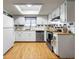 Functional kitchen with white cabinets, stainless steel appliances, and ample counter space under a skylight at 8973 Sw 103Rd Ln, Ocala, FL 34481
