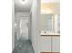 Hallway view with bathroom, including a single sink vanity and tile shower at 9330 Sw 84Th Ter # A, Ocala, FL 34481