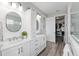 Bright bathroom with double vanity, white cabinetry, and modern fixtures leading to walk-in closet at 9577 Sw 82Nd Street Rd, Ocala, FL 34481