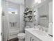 Full bathroom with marble tile, floating shelves and a shower and tub combo at 9577 Sw 82Nd Street Rd, Ocala, FL 34481