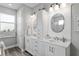 Well-lit bathroom featuring double sinks, storage, modern fixtures, and stylish mirrors at 9577 Sw 82Nd Street Rd, Ocala, FL 34481