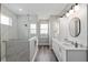 Beautiful bathroom with a glass enclosed shower, double sink vanity and warm wood-like flooring at 9577 Sw 82Nd Street Rd, Ocala, FL 34481