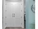 Elegant double doors leading to a bedroom, complemented by stylish hardware and soft blue walls at 9577 Sw 82Nd Street Rd, Ocala, FL 34481