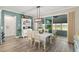 Dining area with table and chairs, light fixture, blue accent wall and sliding glass door to the screened in porch at 9577 Sw 82Nd Street Rd, Ocala, FL 34481