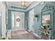 Inviting entryway with decorative glass door, transom window, chandelier, and blue accent wall at 9577 Sw 82Nd Street Rd, Ocala, FL 34481