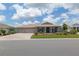 Charming home featuring a well-manicured lawn, a three-car garage, and a covered front porch at 9577 Sw 82Nd Street Rd, Ocala, FL 34481