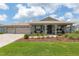 Charming single-story home with manicured front yard, covered porch, and three-car garage at 9577 Sw 82Nd Street Rd, Ocala, FL 34481