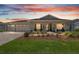 Charming single-story home with manicured front yard, covered porch, and three-car garage at sunset at 9577 Sw 82Nd Street Rd, Ocala, FL 34481