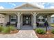 Inviting front porch with comfortable seating, decorative columns, and brick pathway at 9577 Sw 82Nd Street Rd, Ocala, FL 34481
