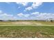 Expansive green space surrounded by single-Gathering homes under a sunny, blue sky with puffy white clouds at 9577 Sw 82Nd Street Rd, Ocala, FL 34481