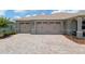 Spacious three-car garage with brick paver driveway and well-maintained landscaping at 9577 Sw 82Nd Street Rd, Ocala, FL 34481