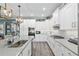Bright kitchen features white cabinets, gray counters, stainless appliances, and a kitchen island with a sink and pendant lights at 9577 Sw 82Nd Street Rd, Ocala, FL 34481