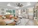 Cozy living room with a large ceiling fan, neutral furniture, and soft natural light from windows at 9577 Sw 82Nd Street Rd, Ocala, FL 34481