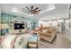 Spacious living room showcasing a large ceiling fan, entertainment center, and open access to the kitchen at 9577 Sw 82Nd Street Rd, Ocala, FL 34481
