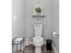 Cozy powder room featuring elegant decor and rustic-style shelving above toilet at 9577 Sw 82Nd Street Rd, Ocala, FL 34481
