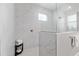 Stylish walk-in shower featuring white marble-like tiling, a rain shower head, and glass enclosure at 9577 Sw 82Nd Street Rd, Ocala, FL 34481