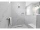 Elegant walk-in shower showcasing white marble-like tiling, a built-in bench, and a shower niche at 9577 Sw 82Nd Street Rd, Ocala, FL 34481