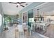 Bright sunroom featuring tile floors, ceiling fan and seamless flow into living space and modern kitchen at 9577 Sw 82Nd Street Rd, Ocala, FL 34481