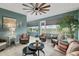 Bright and airy sunroom featuring comfortable wicker furniture, ceiling fan, and tranquil views at 9577 Sw 82Nd Street Rd, Ocala, FL 34481