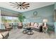 Inviting sunroom with wicker seating, ceiling fan, and serene views of the landscaped surroundings at 9577 Sw 82Nd Street Rd, Ocala, FL 34481