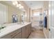 Bright bathroom with a large mirror, under-sink storage, and a shower-tub combo at 10451 Sw 98Th Place Rd, Ocala, FL 34481