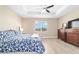 This bright bedroom features wood-look floors, a ceiling fan, and a large window at 10451 Sw 98Th Place Rd, Ocala, FL 34481