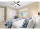 Comfortable bedroom features wood-look floors, and a large window with bright light at 10451 Sw 98Th Place Rd, Ocala, FL 34481