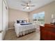 Bedroom with ceiling fan, wood-look floors, and a window offering lots of light at 10451 Sw 98Th Place Rd, Ocala, FL 34481