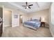 Bright bedroom featuring a tray ceiling, a fan, and a doorway to the attached bath at 10451 Sw 98Th Place Rd, Ocala, FL 34481