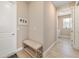 Hallway with tile flooring, a bench, and access to the laundry room at 10451 Sw 98Th Place Rd, Ocala, FL 34481