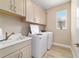 Laundry room features cabinets, a sink, washer, and dryer at 10451 Sw 98Th Place Rd, Ocala, FL 34481