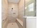 The large, modern shower stall has a built-in bench and a hand-held shower head at 10451 Sw 98Th Place Rd, Ocala, FL 34481
