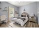 Neutral bedroom featuring wood-look floors, chandelier, writing desk, and a plush bed at 1107 Se 49Th Ave, Ocala, FL 34471