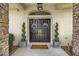 Covered entryway with double doors, decorative wreaths, and spiral topiary accents at 1107 Se 49Th Ave, Ocala, FL 34471