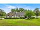 Beautiful single-story home with stone accents, mature landscaping, and lush green lawn at 1107 Se 49Th Ave, Ocala, FL 34471